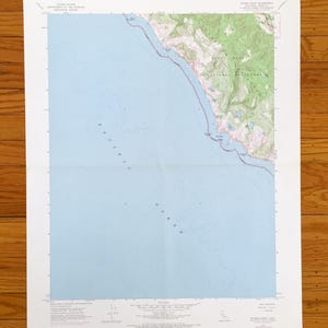 May include: A folded topographic map of the Double Point Quadrangle, featuring coastal and inland geographical details. The map shows the Pacific Ocean in light blue, with land areas in green and brown, and contour lines.