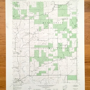 May include: A black and white map of the Mark Twain National Forest in Missouri. The map shows the location of various features, including roads, trails, streams, and landmarks. The map also includes the names of several towns and cities in the area.