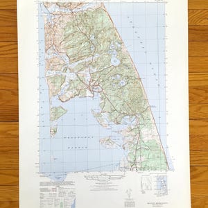 Puede incluir: Un mapa antiguo de Wellfleet, Massachusetts, con información topográfica detallada. El mapa muestra la costa, las carreteras y los elementos naturales en tonos de azul, verde y marrón. El título "Wellfleet" es visible en la parte superior.