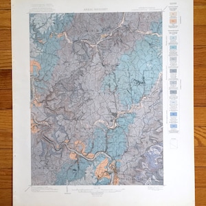 Peut inclure: Une carte géologique vintage de la Pennsylvanie, montrant le quadrangle de Connelleville. La carte est imprimée en noir et blanc avec des zones colorées indiquant différentes formations géologiques. La carte comprend une légende et une échelle.