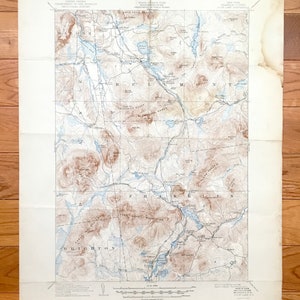 Könnte beinhalten: Eine Vintage-Karte der Gegend um die Stadt Brighton, New York. Die Karte zeigt die Lage von Bergen, Flüssen, Seen und Straßen. Die Karte ist auf cremefarbenem Papier gedruckt und hat ein braunes und blaues Farbschema.