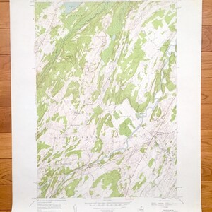 May include: A vintage topographic map of the Rockville quadrangle in New York, printed by the United States Department of the Interior Geological Survey. The map shows the area's terrain, rivers, and roads. The map is printed in black, green, and brown.