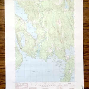 Könnte beinhalten: Eine alte topografische Karte des Sebago-Sees in Maine mit detaillierten Konturen und Beschriftungen. Die Karte zeigt die Uferlinie des Sees, die Inseln und das umliegende Gelände. Sie enthält den Text "UNITED STATES DEPARTMENT OF THE INTERIOR GEOLOGICAL SURVEY" und "NAPLES QUADRANGLE MAINE-CUMBERLAND CO. 7.5 MINUTE SERIES TOPOGRAPHIC."