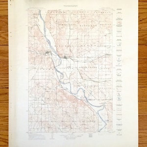 Puede incluir: Un mapa topográfico vintage de la zona de Apple Creek, Ohio. El mapa muestra el río serpenteando por el campo, con carreteras, pueblos y otras características marcadas. El mapa está impreso en papel color crema con un tinte marrón claro.