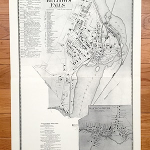May include: A vintage black and white map of Bellows Falls, Vermont, with a detailed depiction of the town's layout, including streets, buildings, and the Connecticut River. The map includes the text "Bellows Falls" and a directory.