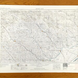 Könnte beinhalten: Eine Vintage-Karte von Broken Bow, Oklahoma, gedruckt auf weißem Papier mit blauen Linien und Text. Die Karte zeigt Straßen, Flüsse und andere geografische Merkmale. Die Karte ist in der oberen rechten Ecke mit "Broken Bow" betitelt.
