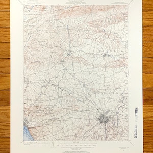 Peut inclure: Une carte topographique ancienne du comté de Lancaster, en Pennsylvanie, avec des courbes de niveau, des routes et des noms de lieux détaillés. La carte présente une palette de couleurs beige et marron, avec le texte "GEOSCIENCE DEPARTMENT" imprimé verticalement.