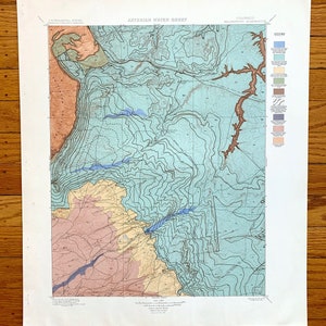 May include: A vintage map of the Artesian Water Sheet in the Walsenburg Quadrangle of Colorado. The map is printed on paper and shows the geological features of the area, including the location of wells and springs. The map is in blue, green, yellow, and brown tones.