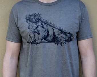 Peut inclure: Un t-shirt gris chiné avec une illustration en noir et blanc d'un iguane sur le devant.