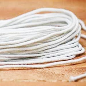May include: A close-up of a white cotton cord, coiled and ready for use. The cord is soft and flexible, perfect for crafting projects.