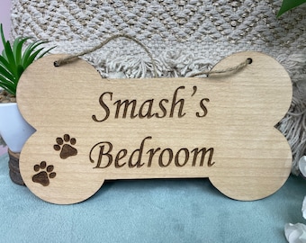 May include: A wooden dog bone shaped sign with the text "Smash's Bedroom" and two paw prints.