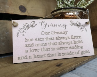 May include: A pink wooden sign with a floral design and the text "Granny Our Granny has ears that always listen and arms that always hold a love that is never ending and a heart that is made of gold."
