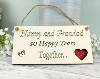May include: Wooden sign with the text "Nanny and Grandad 40 Happy Years Together..." with a red glitter heart and a butterfly design.
