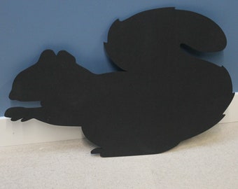 May include: Black silhouette of a squirrel cutout, made of chalkboard material.