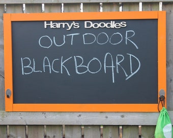 Może przedstawiać: Tablica kredowa w pomarańczowej ramie z napisem "Harry's Doodles Outdoor Blackboard" napisanym białą kredą.
