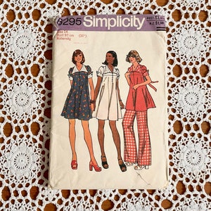 May include: Vintage Simplicity sewing pattern number 6295 for a maternity dress. The pattern includes three different styles of dresses, one with a floral print, one white, and one red and white gingham. The pattern is for a size 14, bust 92 cm.