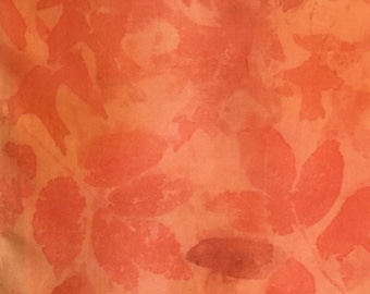 Könnte beinhalten: Orangener Stoff mit einem bedruckten Blattmotiv. Die Blätter sind in einem dunkleren Orangeton gehalten und zufällig über den Stoff verteilt.