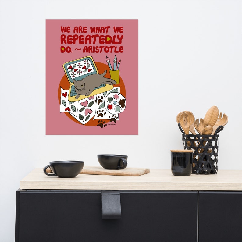 May include: A pink background with a quote from Aristotle: "We are what we repeatedly do."  A cartoon cat is sitting on a laptop computer with paintbrushes, paint, and hearts on the screen.