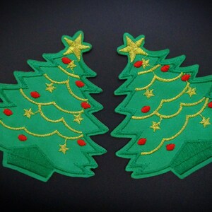 May include: Two green felt Christmas tree patches with gold thread outlining the tree and ornaments, red felt ornaments, and gold star toppers.