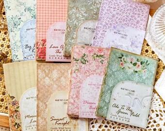 May include: A set of ten decorative paper sheets with floral and patterned designs. Each sheet has a title and text in English and Chinese. The titles include "By the Rose", "Love of the Wind", "Dream Balloon", "Ode to the Green Field", "Moon Love", and "Sunset Knight".