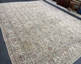 May include: A large, rectangular rug with an intricate floral pattern in shades of beige, cream, and burgundy. The rug features a detailed border with repeating floral and geometric designs, creating a vintage aesthetic.
