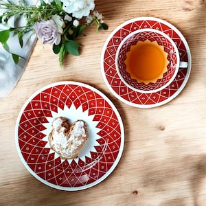 Weimar Porzellan Kahla Sammeltasse mit Engobemalerei in kräftigem Rot und geometrischem Dekor, bestehend aus Tasse, Untertasse und Kuchenteller. Handbemalt, vermutlich 1950er–1970er Jahre, mit charakteristischem DDR Mid Century Design und feiner Linienführung. Ideal für Sammler:innen und Nostalgieliebhaber:innen.