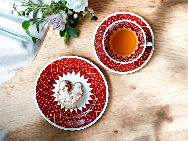 Weimar Porzellan Kahla Sammeltasse mit Engobemalerei in kräftigem Rot und geometrischem Dekor, bestehend aus Tasse, Untertasse und Kuchenteller. Handbemalt, vermutlich 1950er–1970er Jahre, mit charakteristischem DDR Mid Century Design und feiner Linienführung. Ideal für Sammler:innen und Nostalgieliebhaber:innen.