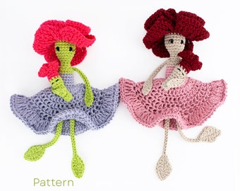 Op de afbeelding: Twee gehaakte poppen met bloemvormige hoofden en lange benen. Eén pop heeft een roze bloemenhoofd en een paarse jurk, de andere heeft een rode bloemenhoofd en een roze jurk. De poppen zitten op een witte achtergrond. Pattern.