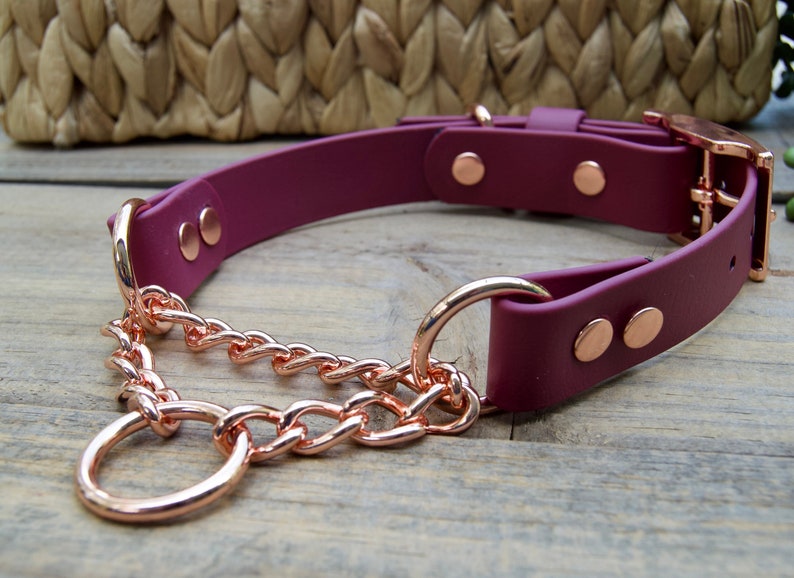 Pu&ograve; includere: Un collare per cani in pelle marrone con una catena e una fibbia in oro rosa. Il collare ha due rivetti in oro rosa su ogni lato.