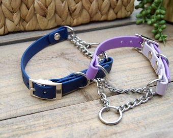 Könnte beinhalten: Zwei Hundehalsbänder, eines blau und eines lila, mit einer silbernen Kette, die sie verbindet. Die Halsbänder sind aus einem weichen, flexiblen Material.