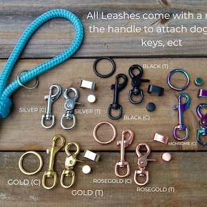 Puede incluir: Primer plano de varias opciones de herrajes para correas, incluyendo acabados en plata, negro, oro, oro rosa y cromo arco&iacute;ris. Cada opci&oacute;n incluye un clip y un anillo. El texto "All Leashes come with a ring on the handle to attach dog bags, keys, ect" es visible en la parte superior de la imagen.