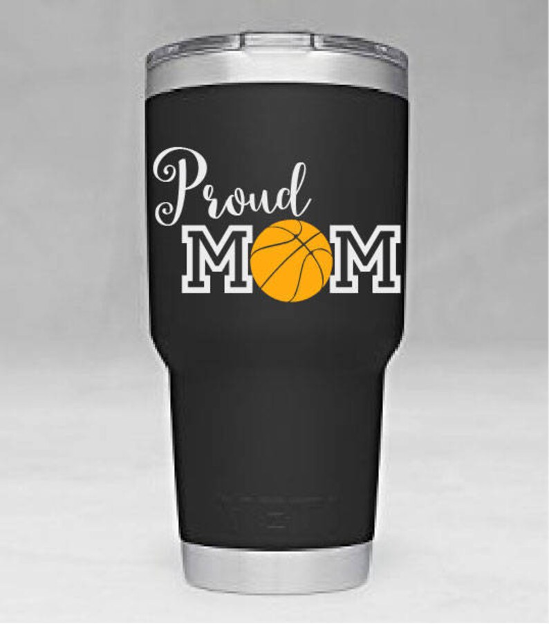 May include: Black stainless steel tumbler with a white graphic that says "Proud Mom" with a basketball in the middle of the word "Mom".