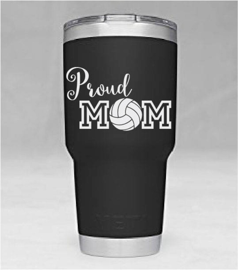 May include: Black and silver stainless steel tumbler with a white vinyl decal that says "Proud MOM" with a volleyball graphic.