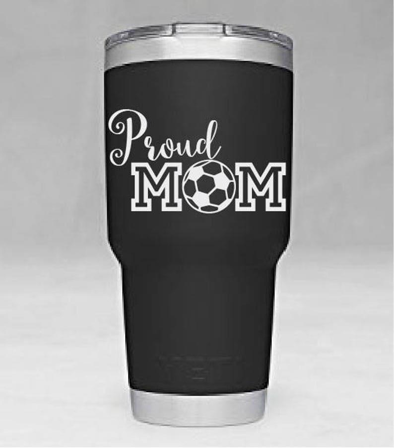 May include: Black stainless steel tumbler with a white design that says "Proud Mom" with a soccer ball in the middle of the word "Mom".