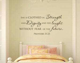 May include: A wall decal with a quote from Proverbs 31:25, "She is clothed in strength and dignity and she laughs without fear of the future." The decal is brown and is placed above a white bed with pink and yellow bedding.