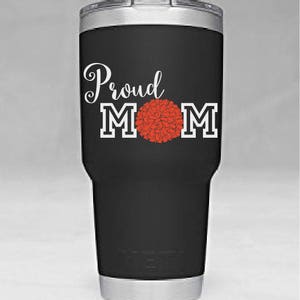 May include: Black stainless steel tumbler with a white design that says "Proud Mom" with a red pom-pom in the middle of the word "Mom".