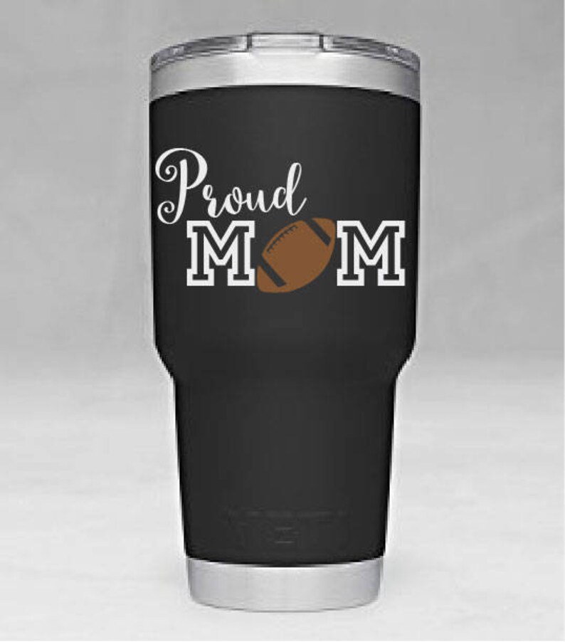 May include: Black stainless steel tumbler with a white design that says "Proud Mom" with a football graphic.