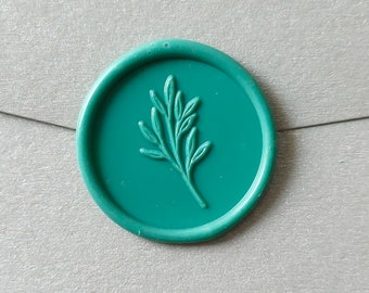 May include: A teal green wax seal with a raised design of a leafy branch.