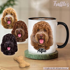 May include: A white ceramic coffee mug with a black handle features a colorful illustration of a brown and white doodle dog with the name "Alfie" printed below. Three additional doodle dog illustrations are shown in the background.