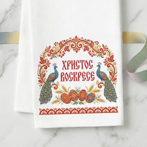 May include: White kitchen towel with a colorful Easter design. The design includes two peacocks, Easter eggs, and the text "Христос Воскресе" in red. The towel has a decorative border and is likely made of cotton.
