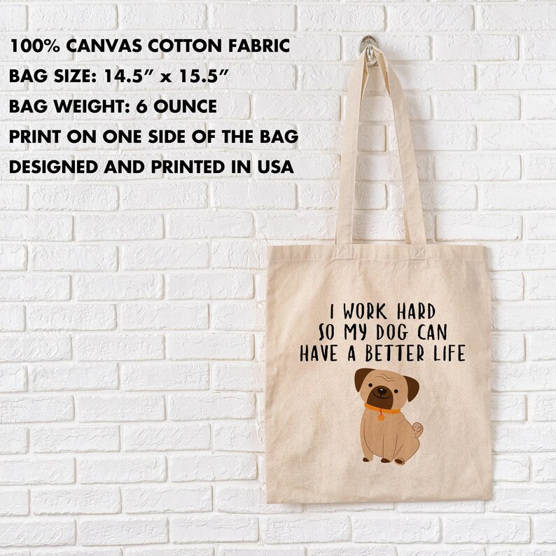 Dog lover canvas tote hanging on a white brick wall beside an infographic listing 14.5x15.5-inch size, 6-ounce bag weight, and one-sided printing.
