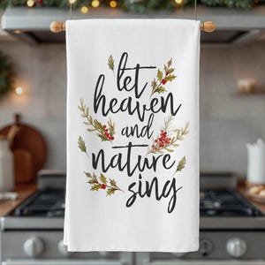 May include: White kitchen towel with a floral design and the text "let heaven and nature sing".