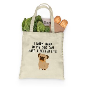 Sturdy grocery tote filled with leafy vegetables, baguettes, and a newspaper against a white background.