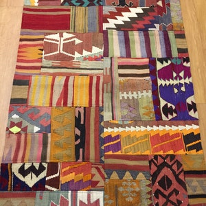 Puede incluir: Una alfombra de patchwork colorida con una variedad de patrones geométricos en tonos de rojo, naranja, amarillo, verde, azul, morado y marrón.