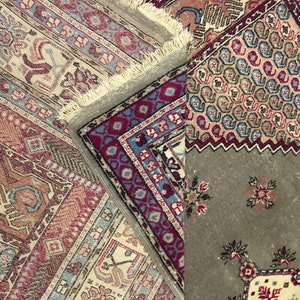 May include: Close-up of a multi-colored rug with intricate patterns. The rug is made of wool and has a fringe border. The rug is folded in half, revealing a different pattern on the underside.