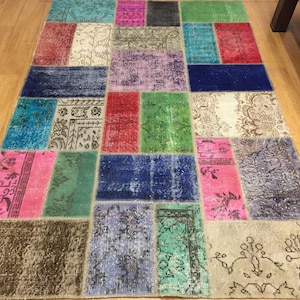 May include: A patchwork rug with a variety of colors and patterns, including blue, green, pink, red, and white. The rug is made of different pieces of fabric sewn together.