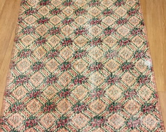 May include: A vintage style rug with a diamond pattern in shades of beige, green, and red. The rug has a floral design with a distressed look.