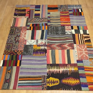 Può includere: Un tappeto patchwork colorato con una varietà di motivi geometrici e a righe in tonalità di rosso, arancio, giallo, verde, blu e marrone.