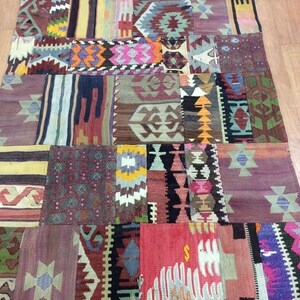 May include: A colorful patchwork rug with a variety of geometric patterns in shades of red, blue, green, yellow, and brown.