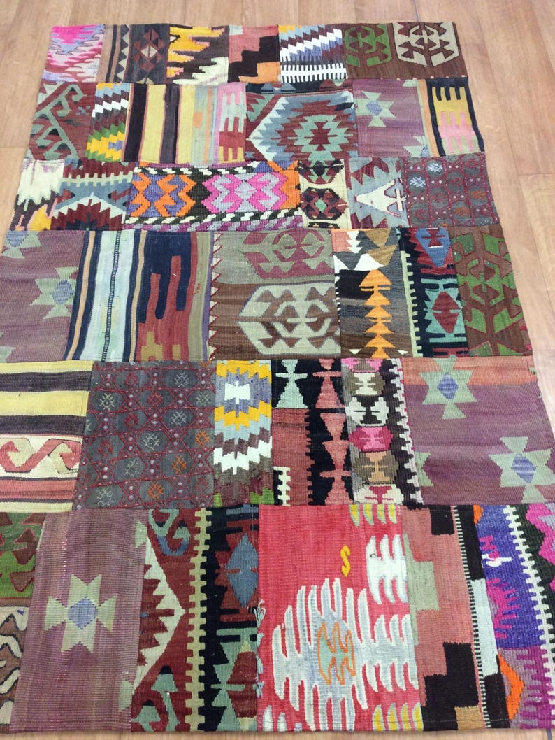 May include: A colorful patchwork rug with a variety of geometric patterns in shades of red, blue, green, yellow, and brown.